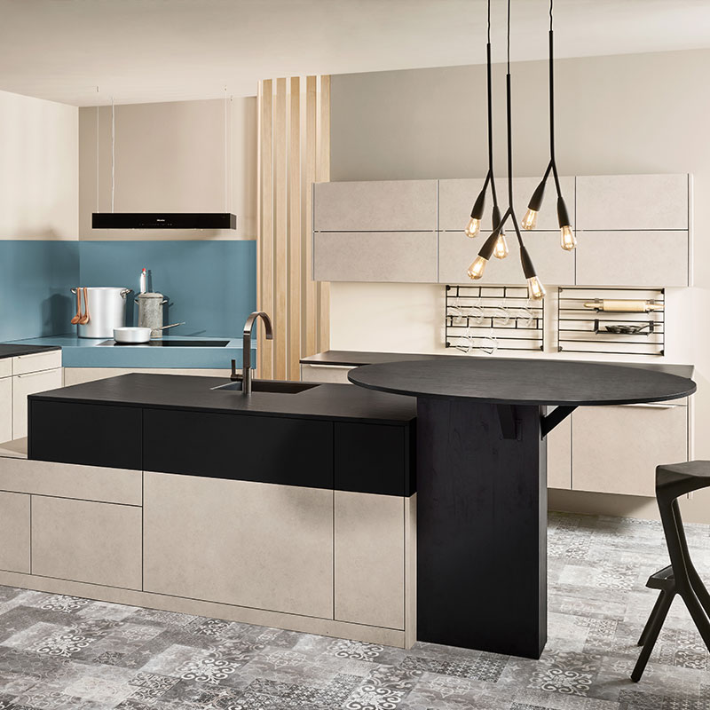 Moderne keuken in beige, zwart en blauw met kookeiland, ronde tafel en hanglampen